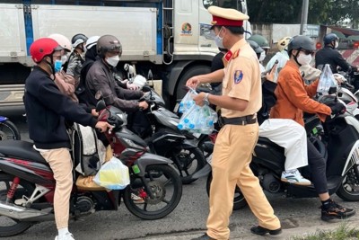Cảnh sát giao thông phát nước, khăn lạnh cho người dân về quê đón Tết