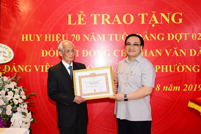 Bí thư Thành ủy Hoàng Trung Hải trao huy hiệu đảng cho đảng viên lão thành