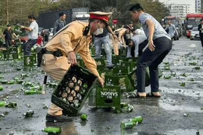 Cảnh sát giao thông cùng người dân thu dọn hàng trăm thùng bia rơi xuống đường