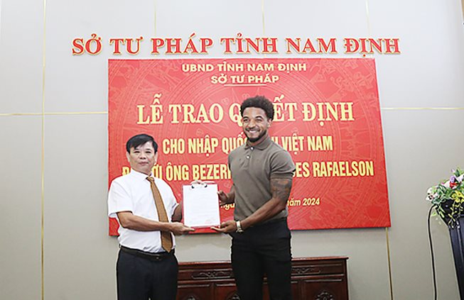 Lãnh đạo Sở Tư pháp Nam Định trao quyết định của Chủ tịch nước cho nhập quốc tịch Việt Nam tới cầu thủ Rafaelson. Ảnh: DH