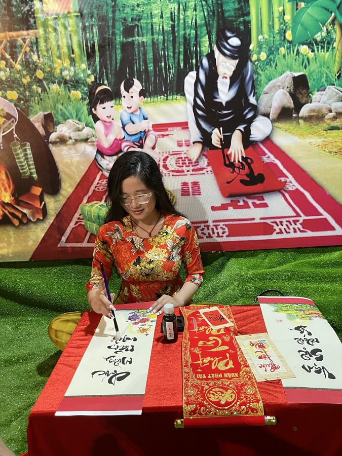 MỘt bạn trẻ đang "thử sức" với bức thư pháp tại một ngôi chùa ở Kiên Giang trong đêm Giao thừa