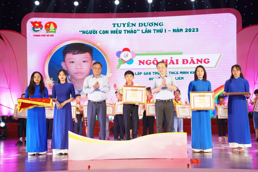 Phó Trưởng ban Thường trực ban Dân vận Trung ương Phạm Tất Thắng và Phó Bí thư Thành ủy Hà Nội Nguyễn Văn Phong trao tặng Bằng khen cho gương "Người con hiếu thảo".