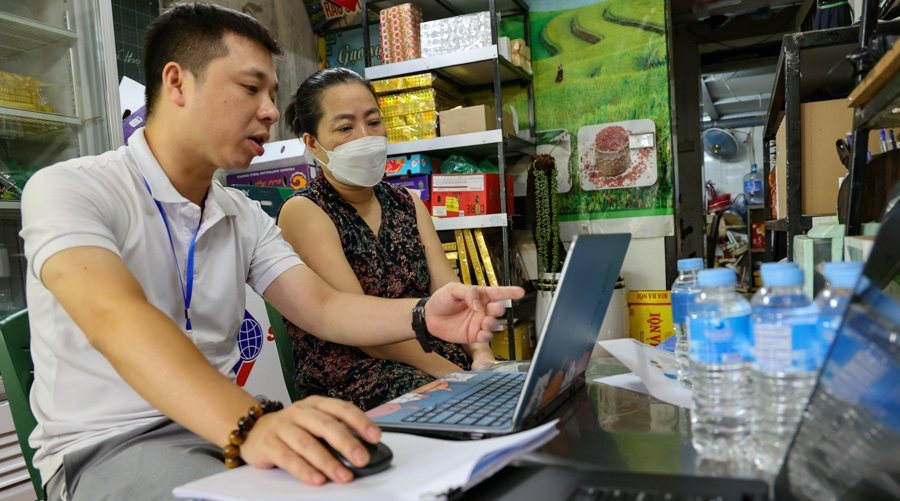 Cán bộ phường Trúc Bạch (quận Ba Đình) hướng dẫn người dân thực hiện các dịch vụ công trực tuyến. 