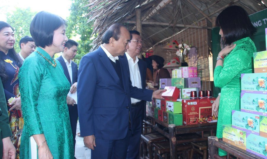 Nguyên Chủ tịch nước Nguyễn Xuân Phúc tham quan các gian hàng trưng bày tại Ngày hội. 
