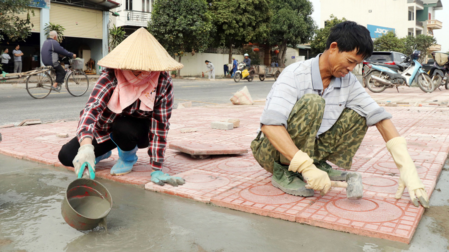 Công nhân thi công vỉa hè trên tuyến đường Thanh Niên, phường Dĩnh Kế.
