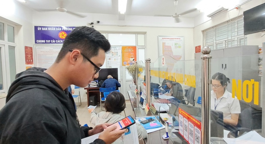 Công dân quét mã QR để trả phí giải quyết thủ tục hành chính tại bộ phận một cửa phường Đồng Tâm, quận Hai Bà Trưng. Ảnh: Thùy Linh