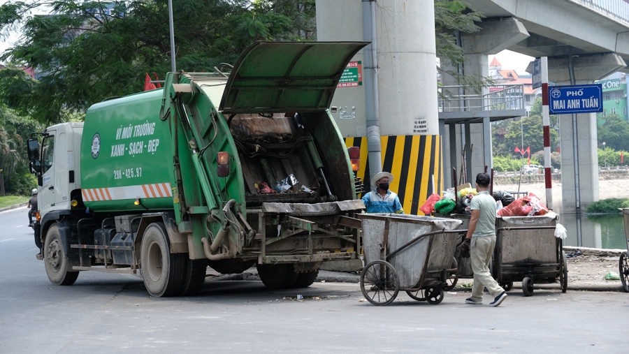 Công nhân vệ sinh môi trường thu gom rác thải đảm đảo cho đường phố Hà Nội sạch đẹp. Ảnh: Công Hùng 