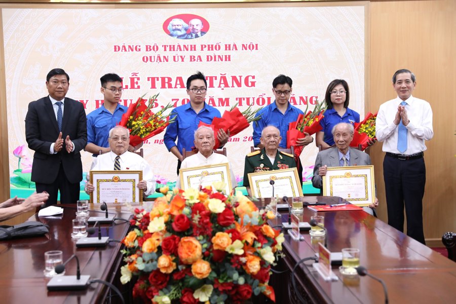 Trưởng ban Dân vận Thành ủy Đỗ Anh Tuấn và Bí thư Quận ủy Ba Đình Hoàng Minh Dũng Tiến trao Huy hiệu 75 năm tuổi Đảng cho các đảng viên lão thành. 