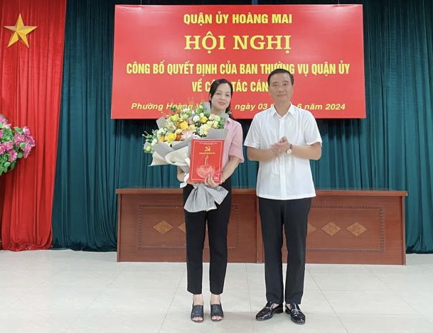 Bí thư Quận ủy Nguyễn Xuân Linh trao quyết định cho Bí thư Đảng uỷ phường Hoàng Văn Thụ Lê Thị Thu Hương. Ảnh HM