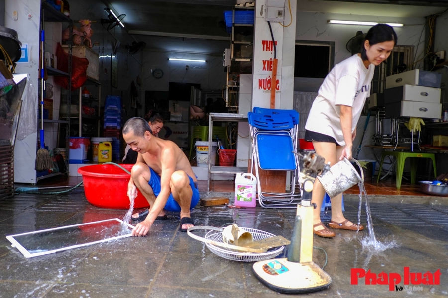 Người dân phố Chương Dương Độ, quận Hoàn Kiếm dọn dẹp nhà cửa sau mưa lũ. Ảnh: Khánh Huy. 