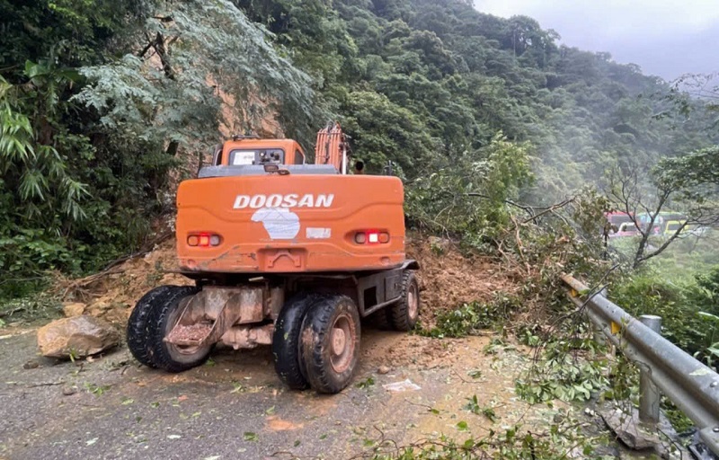 Các lực lượng chức năng huy động máy móc dời dọn đất đá, cây cối bị sạt lở trên tuyến quốc lộ 8A khu vực Cửa khẩu quốc tế Cầu Treo