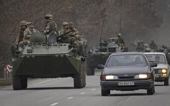 Quân nhân Ukraine ngồi trên xe bọc thép di chuyển trên một con đường ở vùng Donetsk, miền đông Ukraine, ngày 24-2 - Ảnh: AP
