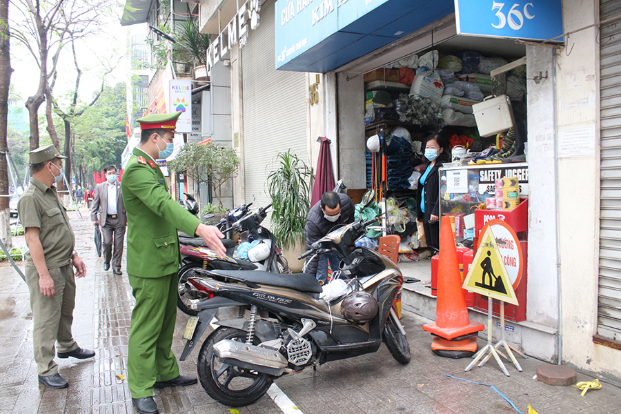 Công an phường Điện Biên, quận Ba Đình nhắc nhở các hộ kinh doanh trên tuyến phố Nguyễn Thái Học đảm bảo trật tự đô thị. 