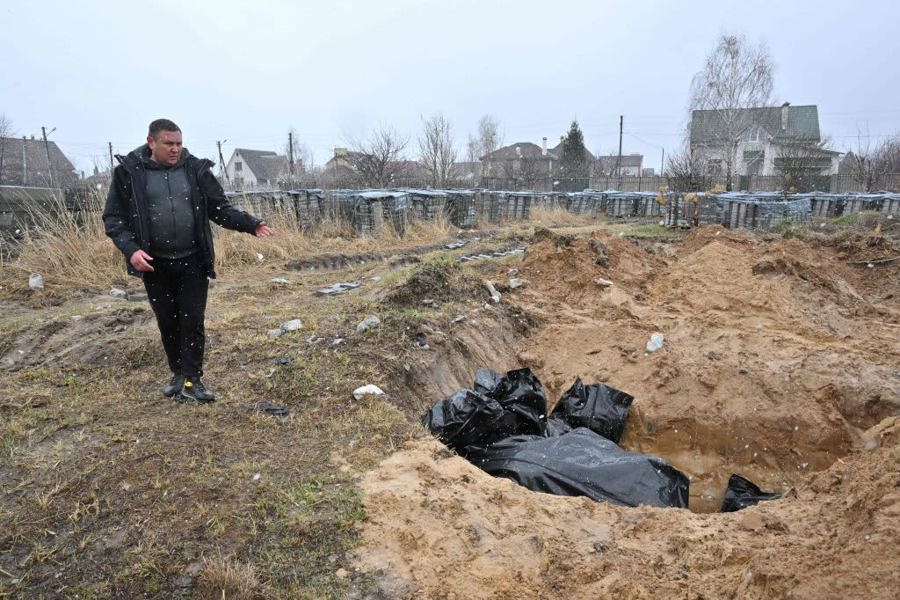 Người đàn ông được cho là đang ở trước một "ngôi mộ tập thể" ở thị trấn Bucha, phía Tây Bắc thủ đô Kiev của Ukraine vào ngày 3/4/2022. Ảnh: AFP