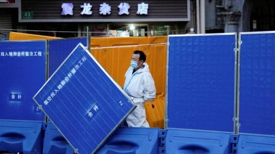 Một nhân viên mặc đồ bảo hộ bên cạnh các rào chắn được đặt xung quanh khu vực bị phong tỏa ở Thượng Hải, Trung Quốc, vào ngày 11/4/2022. Ảnh: Reuters
