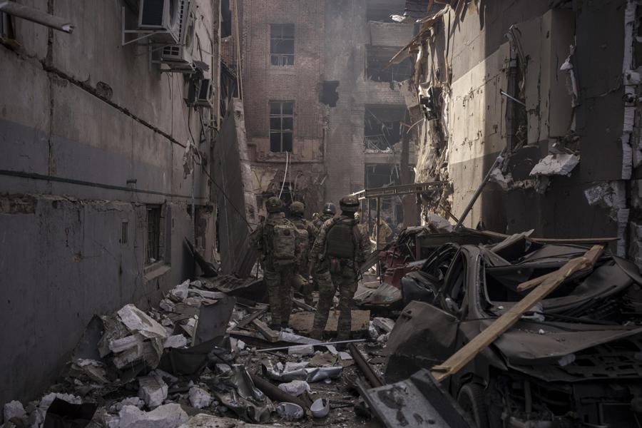 Quân nhân Ukraine giữa đống đổ nát của các tòa nhà bị hư hại sau một cuộc tấn công ở Kharkiv. Ảnh: AP