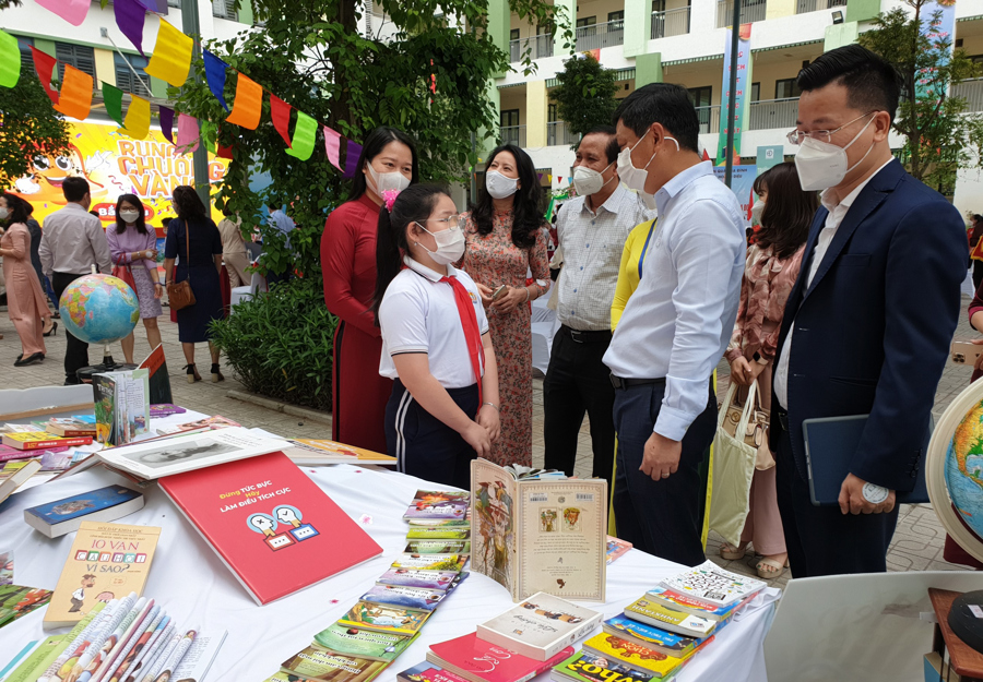 Lãnh đạo quận Ba Đình tham quan và trao đổi với các em học sinh tại gian trưng bày sách. 