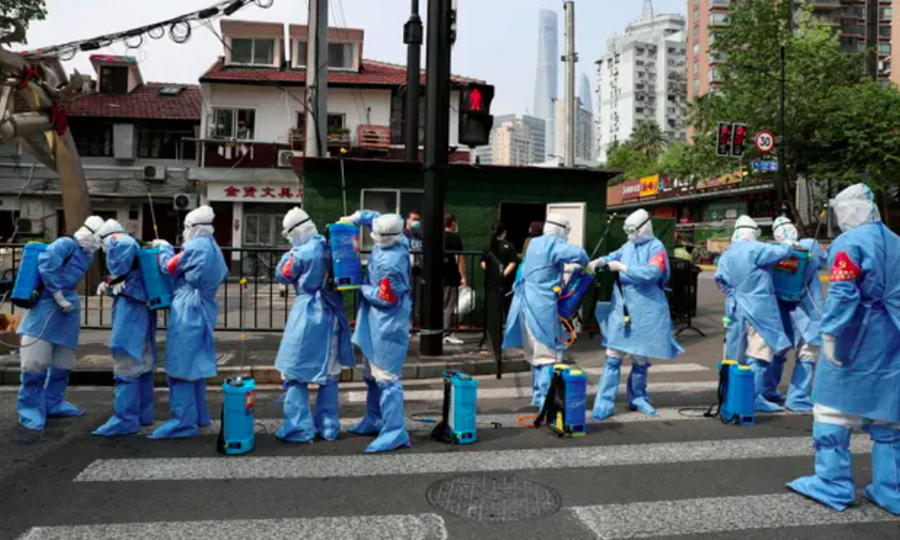 Các nhân viên y tế tiến hành phun khử khuẩn ở một khu dân cư tại Thượng Hải. Ảnh: Reuters