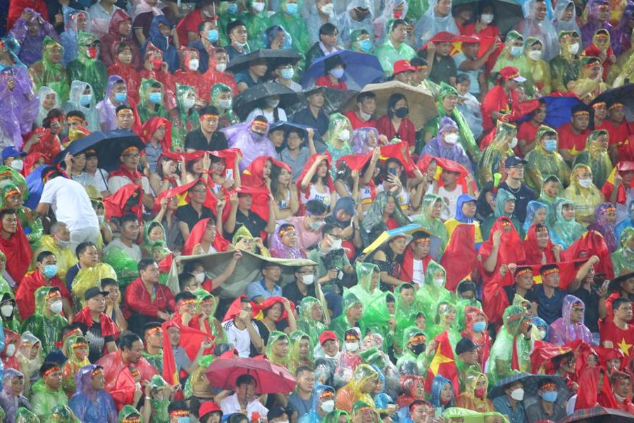 Người hâm mộ đội mưa cổ vũ cho đội tuyển U23 Việt Nam trong trận đấu với U23 Philippines. Ảnh: Hoàng Quân. 
