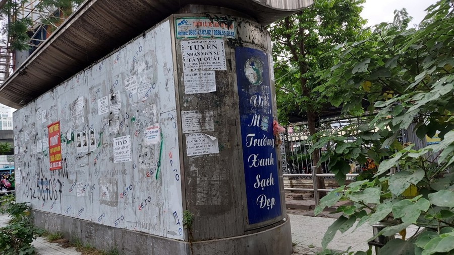 Nhà vệ sinh tại ngã tư đường Phạm Hùng - Nguyễn Hoàng rất nhếch nhác, tường nhà dán đầy quảng cáo.