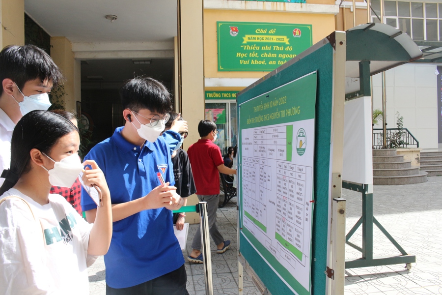 Tình nguyện viên tại điểm thi trường THCS Nguyễn Tri Phương (quận Ba Đình, TP Hà Nội) đang hướng dẫn thí sinh vào phòng thi. 