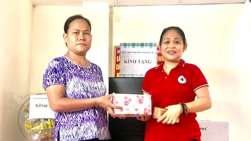 Cán bộ Hội chữ thập đỏ trao quà cho hộ nghèo phường Thanh Trì. Ảnh HM