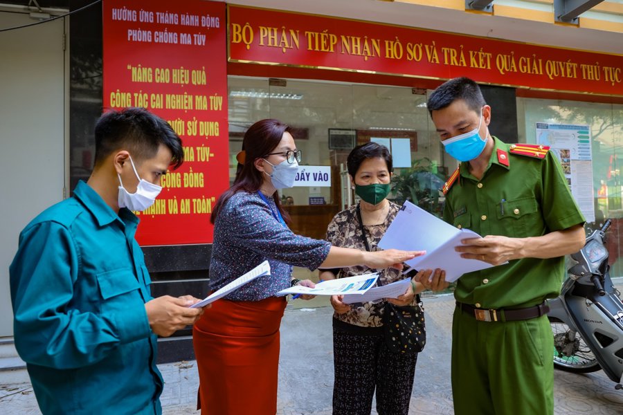 Các thành viên của "Đội cơ động hỗ trợ dịch vụ công trực tuyến tại nhà" đầu tiên tại Hà Nội trao đổi nghiệp vụ và các phương án tiếp cận, hỗ trợ người dân. Ảnh: Trung Nguyên. 