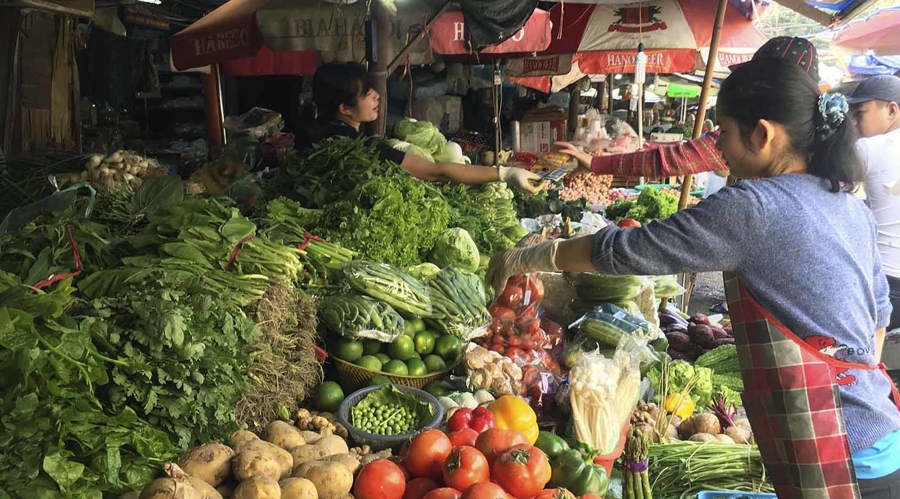 Người tiêu dùng mua rau xanh tại chợ truyền thống