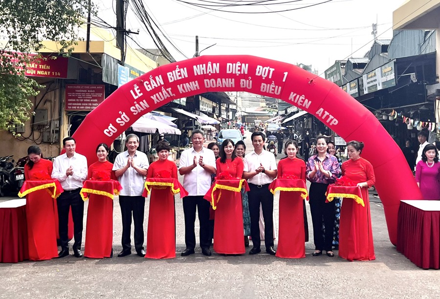 Lãnh đạo TP Hà Nội và lãnh đạo quận Ba Đình thực hiện nghi lễ gắn biển nhận diện cho các cơ sở sản xuất, kinh doanh đủ điều kiện an toàn thực phẩm. 