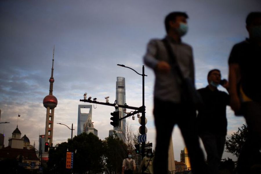 Người dân đeo khẩu trang che mặt đi bộ trên đường phố, sau khi dịch bệnh do Covid-19 bùng phát ở Thượng Hải. Ảnh: Reuters