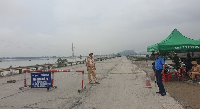 Các lực lượng chức năng lập sào chắn, cảnh báo nguy hiểm trên tuyến Quốc lộ 1A đoạn qua xã Xuân Lam, huyện Nghi Xuân