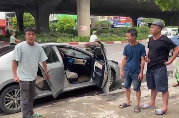 Thiếu tá Nguyễn Ninh Dương (bên trái ảnh) dừng xe ô tô đưa người phụ nữ bị nạn đi cấp cứu. 