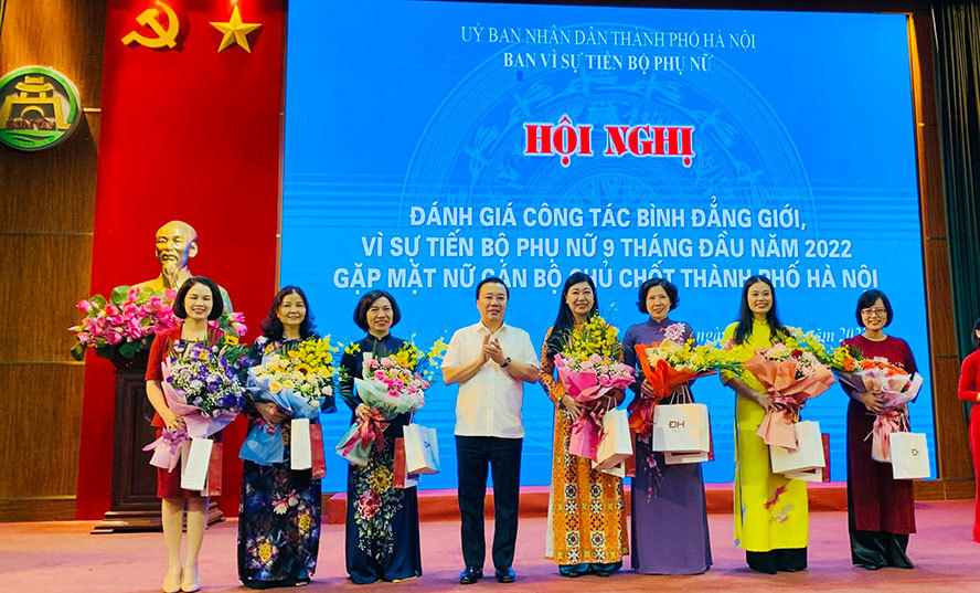 Phó Chủ tịch UBND TP Chử Xuân Dũng, Trưởng ban Vì sự tiến bộ phụ nữ thành phố Hà Nội tặng hoa các nữ cán bộ chủ chốt thành phố.
