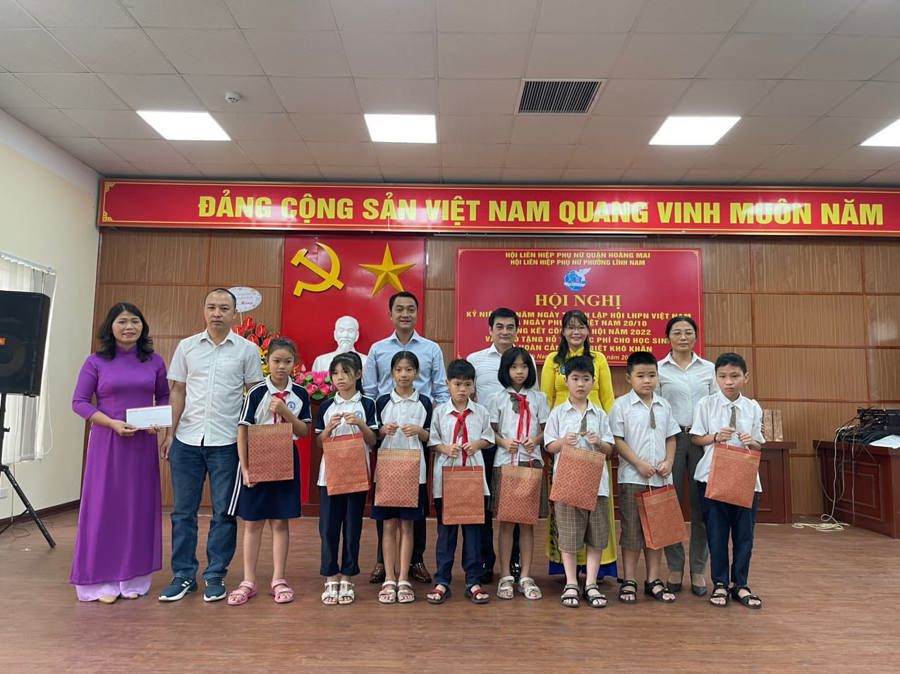 Chị Nguyễn Thu Hà, Chủ tịch Hội LHPN phường Lĩnh Mai (áo vàng) cùng lãnh đạo địa phương tặng quà trẻ em nghèo vượt khó trên địa bàn. Ảnh HM.