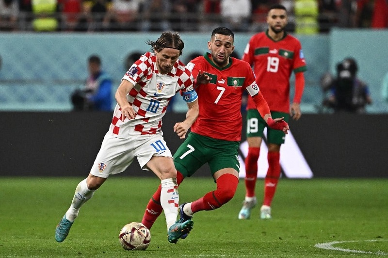 Luka Modric (số 10) tranh chấp bóng cùng Hakim Ziyech (số 7) trong trận đấu tranh huy chương đồng World Cup 2022 giữa Croatia và Morocco. Ảnh: TTXVN/AFP