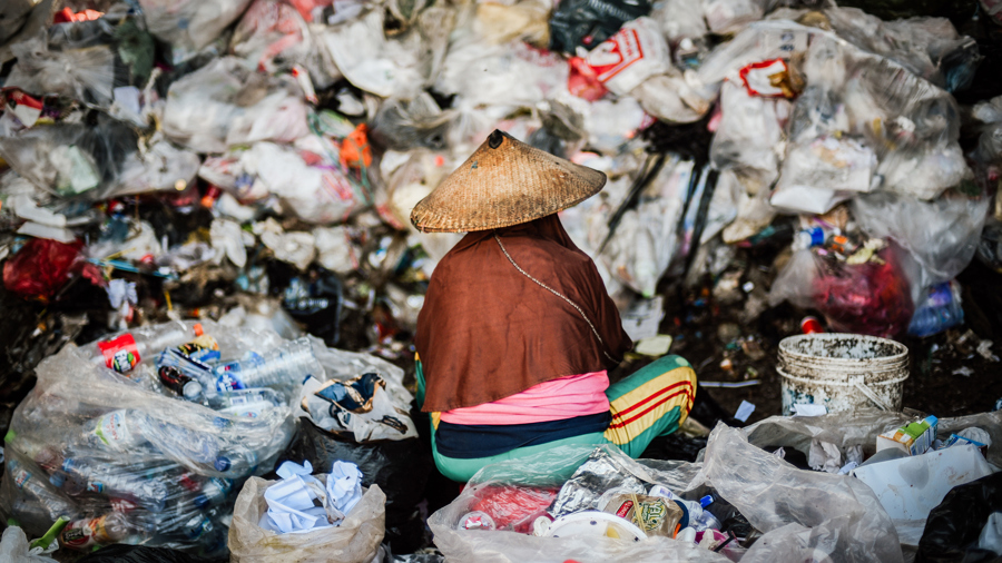 Một phụ nữ ngồi giữa bãi rác ở Indonesia. Nguồn: Nikkei Asia