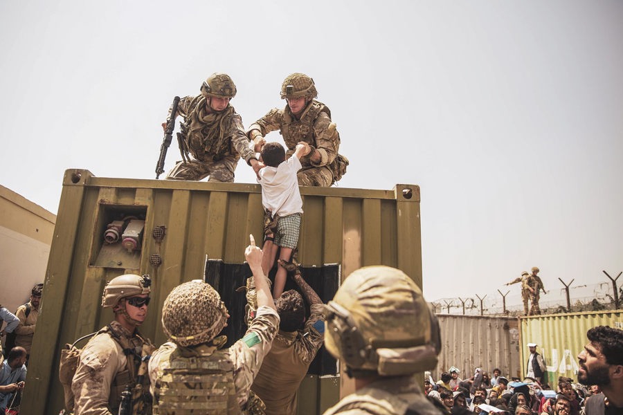 Lính Thủy quân lục chiến Hoa Kỳ hỗ trợ một đứa trẻ trong quá trình sơ tán tại Sân bay Quốc tế Hamid Karzai ở Kabul, Afghanistan. Ảnh: Bộ Quốc phòng Mỹ