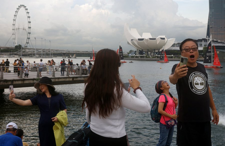Khách du lịch Trung Quốc chụp ảnh tại Vịnh Marina ở Singapore, tháng 5/2023. Ảnh: Reuters