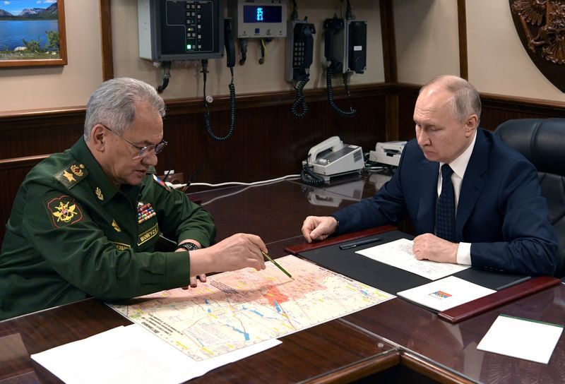Tổng thống Nga Vladimir Putin lắng nghe báo cáo từ Bộ trưởng Quốc phòng Sergei Shoigu, ngày 25/12/2023. Ảnh: Sputnik
