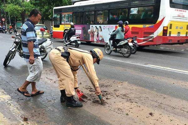 Hà Nội: Cảnh sát giao thông thu dọn lượng bùn đất lớn rơi vãi trên phố - Ảnh 1