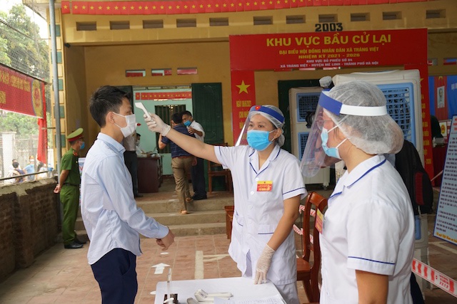 Chùm ảnh: Phòng dịch Covid-19 nghiêm ngặt trong ngày bầu cử lại tại huyện Mê Linh - Ảnh 4