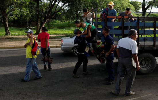 Hình ảnh người dân Venezuela “đu” xe tải đi làm do khủng hoảng giao thông công cộng - Ảnh 11