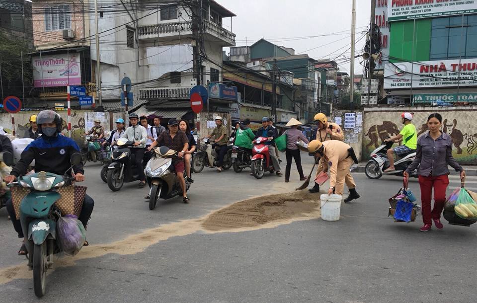 Hà Nội: Cảnh sát giao thông kịp thời thu dọn lượng cát lớn rơi trên đường - Ảnh 1