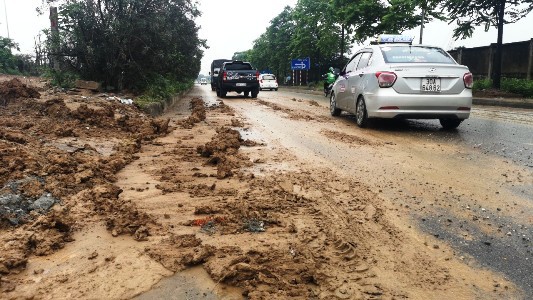 Đội mưa dọn dẹp bùn đất trên Đại lộ Thăng Long - Ảnh 1
