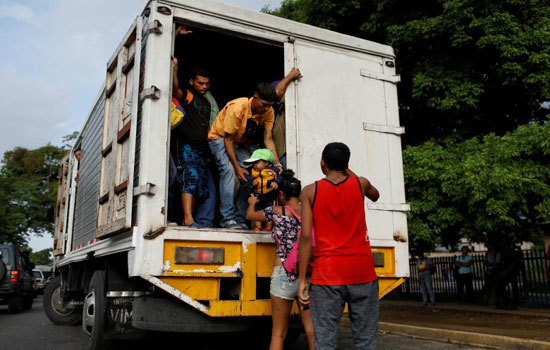 Hình ảnh người dân Venezuela “đu” xe tải đi làm do khủng hoảng giao thông công cộng - Ảnh 9