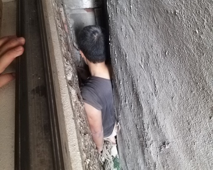 Hà Nội: Người đàn ông mắc kẹt trong khe tường nhà được cảnh sát giải cứu - Ảnh 1