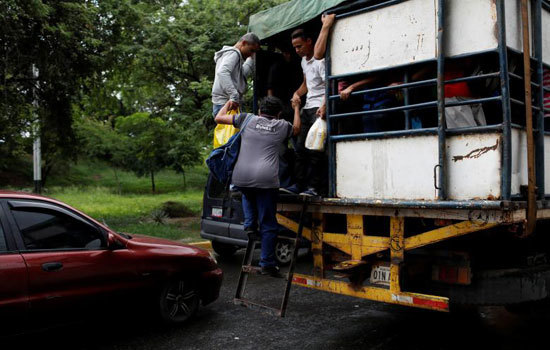 Hình ảnh người dân Venezuela “đu” xe tải đi làm do khủng hoảng giao thông công cộng - Ảnh 7