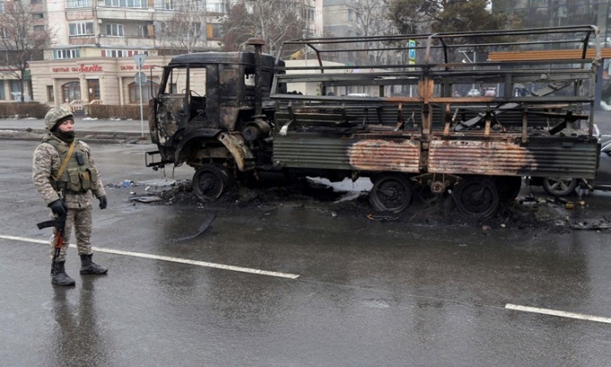 Binh sĩ Kazakhstan đứng g&aacute;c gần một chiếc xe tải bị ch&aacute;y tr&ecirc;n đường phố th&agrave;nh phố Almaty, Kazakhstan,ng&agrave;y 8/1. Ảnh: Reuters. &nbsp;
