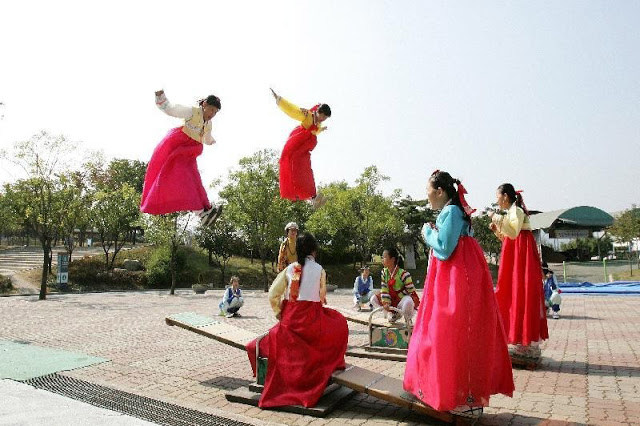 Người H&agrave;n Quốc mặc Hanbok v&agrave; chơi tr&ograve; chơi d&acirc;n gian trong dịp tết Nguy&ecirc;n Đ&aacute;n.