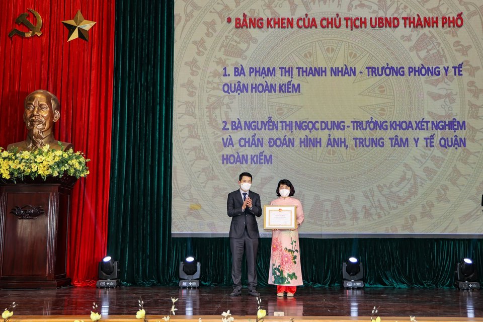 Chủ tịch UBND quận Phạm Tuấn Long trao Bằng khen của Chủ tịch UBND TP cho Trưởng phòng Y tế quận Phạm Thị Thanh Nhàn